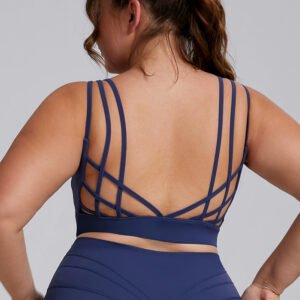 Plus size model wearing breathable plus size strappy back sports bra with criss cross detailing